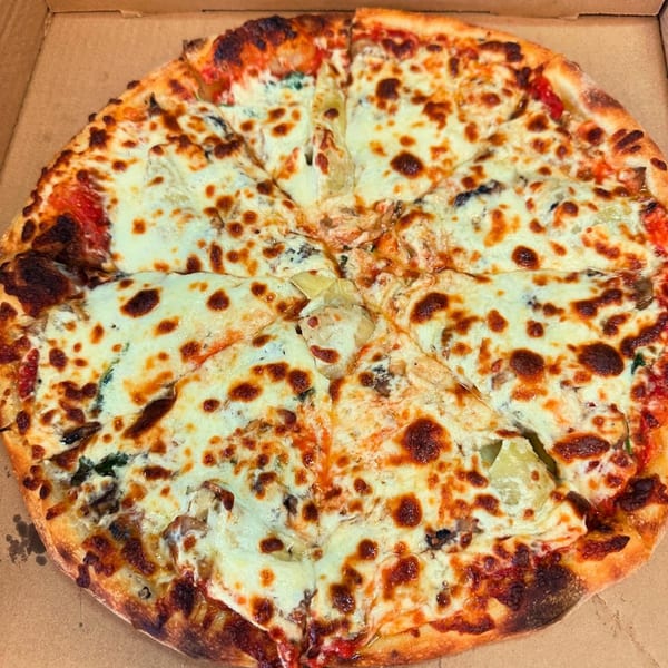 A whole Slice of Martinez pizza, cut into eight slices, with melted cheese and toppings.