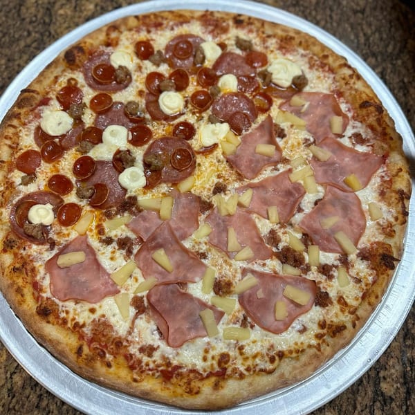 A whole pizza from Slice of Martinez, half pepperoni and sausage, half ham and pineapple.